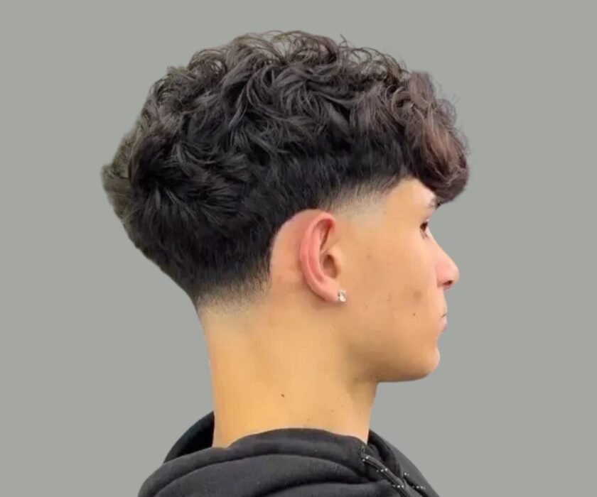 Curly fringe with taper fade - popular men’s hairstyle in Dubai